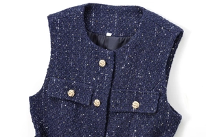 Detail of dark blue tweed vest featuring textured fabric and decorative gold buttons
