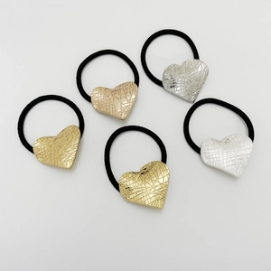 Detail of 5 elastic hair ties featuring textured gold and silver heart-shaped alloy accents