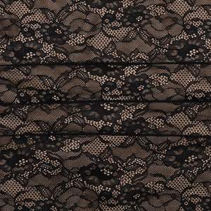 Close-up of black floral lace fabric detailing the mesh structure of the elegant dress