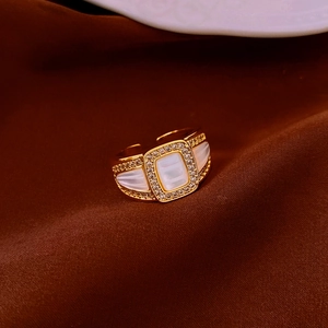 Macro shot of retro gold-plated ring featuring rectangle mother of pearl and pavé crystals