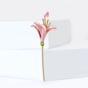 Elegant tulip flower brooch in pink enamel with gold-tone stem on a white background