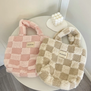Close-up of plush checkerboard tote bags with Hilldi Plan tags on white surface