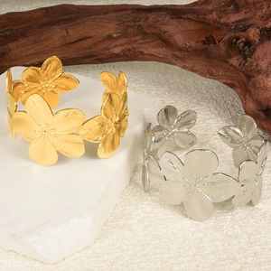 Macro detail of 3D matte flower cuff bracelet in gold and silver finish on stone
