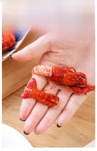 Macro detail of freshly peeled crayfish meat and bright red shells on a wooden table