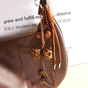 Brown leather crescent bag with leopard print bow and heart beads charm accessory
