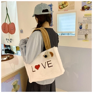 Close-up of white plush tote bag with LOVE embroidery and brown shoulder strap on model