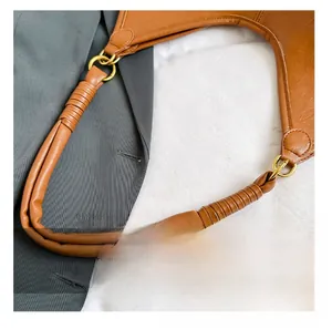 Detail of premium brown leather handle with golden metal rings on a vintage tote bag