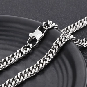 Detail of silver stainless steel curb chain with lobster clasp on a black textured tray