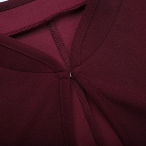 Vue macro détaillée de la texture tissée bordeaux et de l'attache métallique délicate