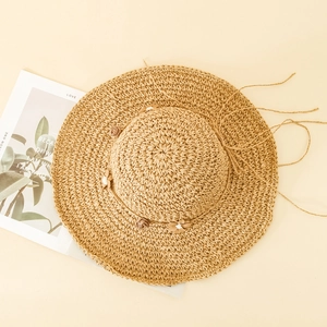 Détail d'un chapeau de paille à larges bords avec fleurs et ruban de réglage
