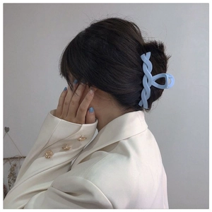 Side view of a light blue twisted shark hair claw clip worn by a model on light hair
