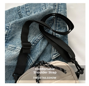 Detail of adjustable nylon strap and plastic buckle on casual off-white crossbody bag