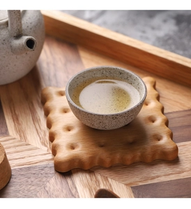 Macro detail of biscuit-shaped walnut wood coaster with heat-resistant surface for mugs
