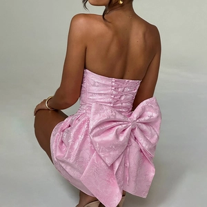 Détail d'une robe bustier rose avec texture florale et grand nœud papillon au dos
