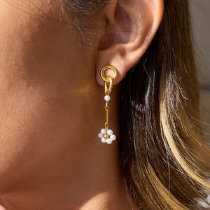 Dettaglio orecchini a fiore con perle su modella con cerchio placcato in oro 18K