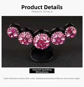 Dettaglio degli strass rosa scintillanti su una pinza per capelli nera da donna