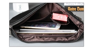 Macro view of the internal compartments and zipper pockets of this black punk clutch bag
