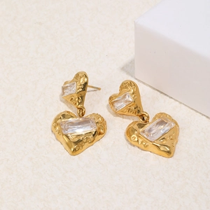 Close-up of hammered gold heart earrings with inset rectangular cubic zirconia