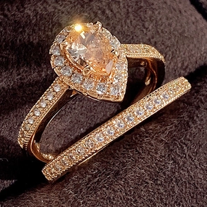 Detail van een ringenset met peervormige champagne zirkoon en pavé micro-inlays in roségoud