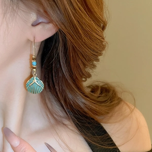 Detail of bohemian starfish earring with turquoise beads on a model side profile