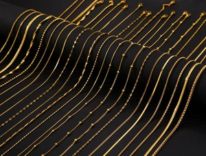 Detail of 18k gold plated stainless steel jewelry chains in various styles on black base