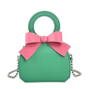 Mini green leather handbag with pink bow, round handle and silver chain strap