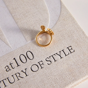 Nahaufnahme eines goldenen Hufeisenrings im Vintage-Stil mit Kronendetails auf Struktur