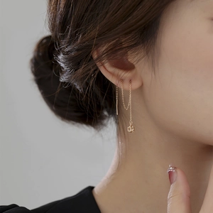 Close-up of elegant gold chain earrings with geometric square drops on model