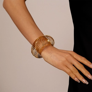 Detail view of the layered spiral spring metal wire bracelet in polished gold finish