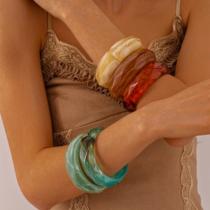 Retro multi-color acrylic resin geometric bangles layered on a model's arm for style