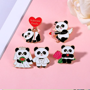 Makroansicht von vier niedlichen Emaille-Panda-Hochzeitsbroschen mit Valentinstagsmotiven
