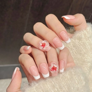 Pink and white French press-on nails with 3D floral carvings and golden bead details