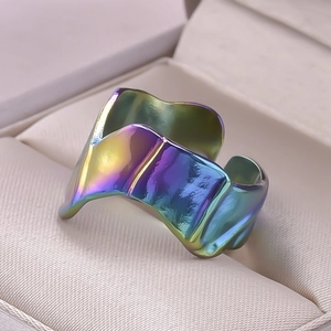 Macro shot of an irregular wave stainless steel ring with a vibrant rainbow iridescent finish