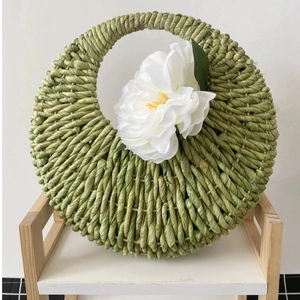 Close-up of green corn rope woven hanging basket with a white decorative flower detail