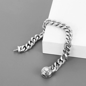 Polished silver cuban link chain necklace with circular clasp on geometric background