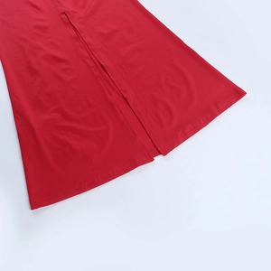 Vue détaillée de l'ourlet de robe de soirée rouge avec fente et texture tricotée
