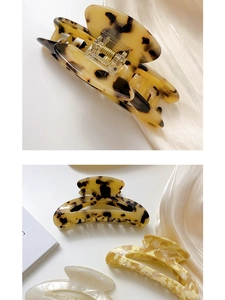Detailed views of a tortoiseshell acetate half-moon hair claw clip with cutout design