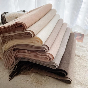Solid cashmere-feel scarves with fringe tassels stacked in various elegant colors