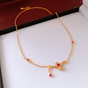 Detail of 24K gold plated star necklace with red heart zircon in a premium jewelry box