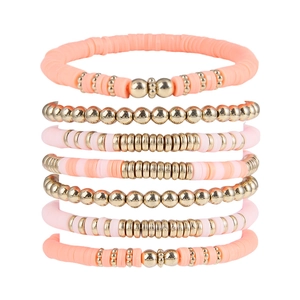 Detail of 7-piece peach and pink polymer clay heishi bead bracelet set with gold accents