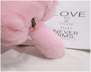 Detailed macro view of pink plush fabric with a brown strap and golden D-ring connector