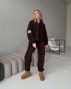 Dettaglio del polsino della felpa in pile marrone con patch ricamata sul braccio