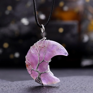Macro shot of purple amethyst crescent moon pendant with silver tree of life wire wrapping