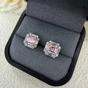 Macro shot of pink Asscher cut stud earrings with white diamond halo in a velvet jewelry box