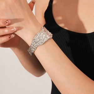 Dettaglio macro del bracciale rigido argento con texture irregolare effetto lava