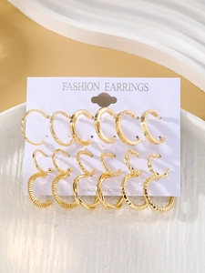 Detail view of a 6-pair gold hoop earring set featuring smooth and twisted metal textures
