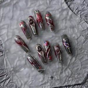 Detail of dark gothic handmade press-on nails with 3D silver relief and red accents