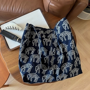 Detailed view of dark blue canvas tote bag with white animal print on wooden table
