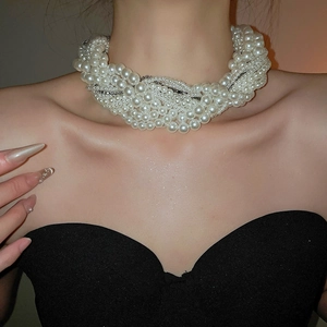 Close-up of multi-layer knotted pearl necklace with sparkling rhinestone chain detail