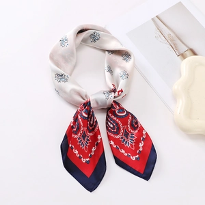 Detail of red and navy paisley silk scarf showing smooth texture and edge stitching
